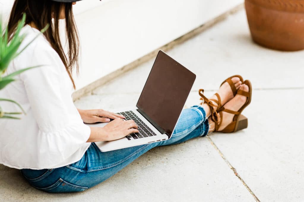 person working on laptop while sitting outside. How To Make Money Without A Job